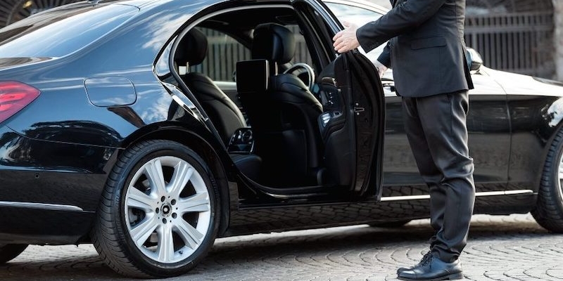 Chauffeur ouvrant la portière d'une berline